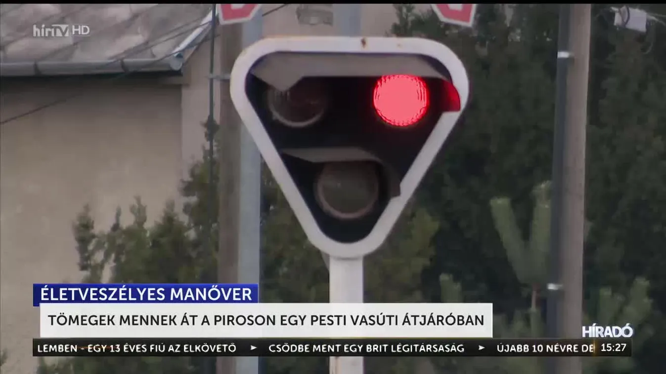 Tömegek mennek át a piroson egy pesti vasúti átjáróban